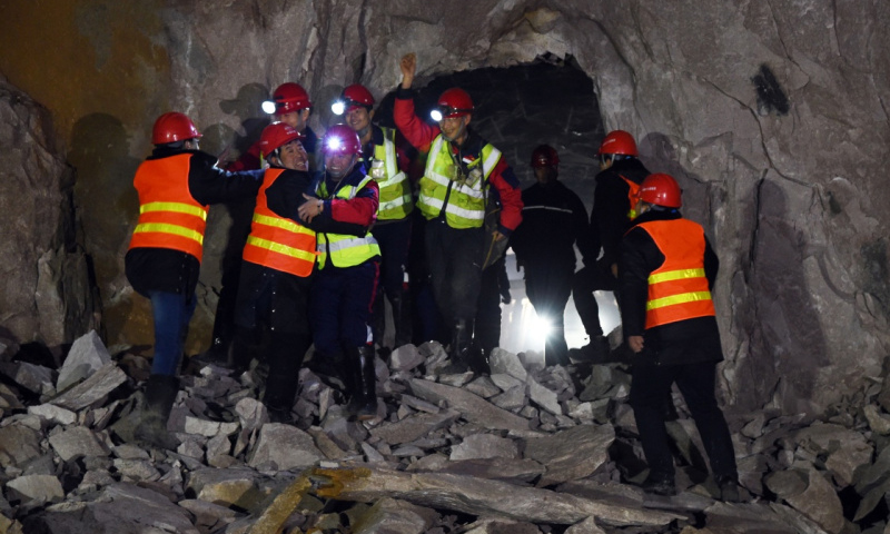 1月7日，2022年北京冬奧會延慶賽區綜合管廊隧道全線貫通。圖為中鐵十四局、中鐵十八局的建設者在管廊隧道貫通處會師慶祝。新華社發（任超 攝）