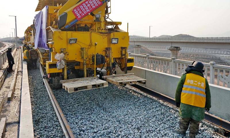 1月6日，由中鐵二十局承建的2022年北京冬奧會配套保障工程——崇禮鐵路鋪軌工程在張家口市下花園區戴家營大橋展開。圖為工人在崇禮鐵路張家口市下花園區戴家營大橋鋪軌現場工作。（新華社記者 楊世堯 攝）