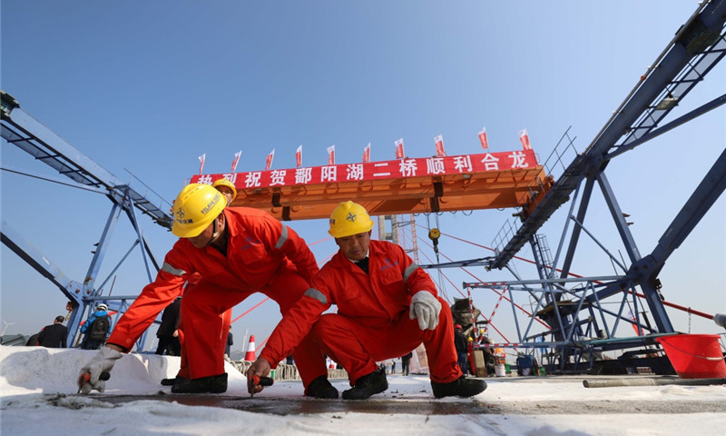 圖為11月28日，兩名工人在鄱陽湖二橋橋面上進行收面施工。新華社發（韓俊烜 攝）