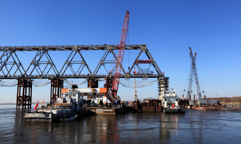 10月13日上午，中俄同江－下列寧斯闊耶鐵路橋重要組成部分——黑龍江特大橋中方最后一吊鋼梁安裝到位，標志著同江中俄鐵路大橋中方段主體工程全部完成。圖為10月13日拍攝的同江中俄鐵路大橋的中方建設部分。（新華社記者 馬知遙 攝）