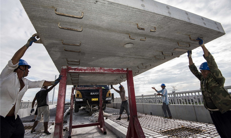 圖為8月30日，中鐵十一局職工在江西省豐城市境內的昌贛高鐵孫渡特大橋上吊裝無砟軌道板。（新華社記者 杜華舉 攝）