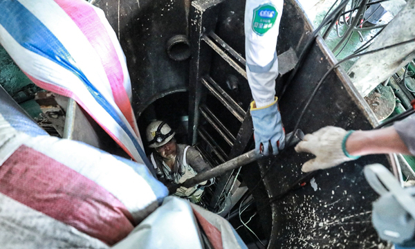 圖為工作人員進入貨油艙內將拆卸的腳手架鋼鐵材料從艙口遞出。（李豫黔 攝）