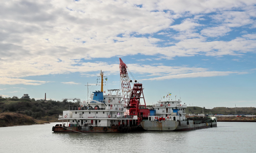 這是2017年10月12日，一組由駁船、運泥船和抓斗式疏浚船組成的清淤單元在烏克蘭敖德薩州南方港施工。由中國港灣工程有限責任公司承攬，中國交建天津航道局有限公司承建的烏克蘭南方港糧食碼頭疏浚工程2018年1月30日舉行竣工簽字儀式。南方港疏浚項目解決了該港口被淤泥阻塞多年的困擾，對烏克蘭進一步擴大糧食出口具有戰略意義。（新華社記者陳俊鋒 攝）