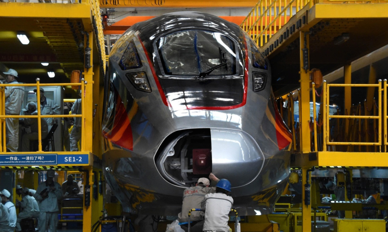 在這里，無論是“和諧號”還是“復興號”，無論運營時速200公里還是350公里，以及正在加緊研發時速600公里高速磁浮列車，中車四方通過創新驅動，助力中國高鐵實現由“跟跑”到“領跑”的彎道超車。圖為5月10日，一輛“復興號”動車組在總裝生產線上裝配。（新華社記者 李紫恒 攝）