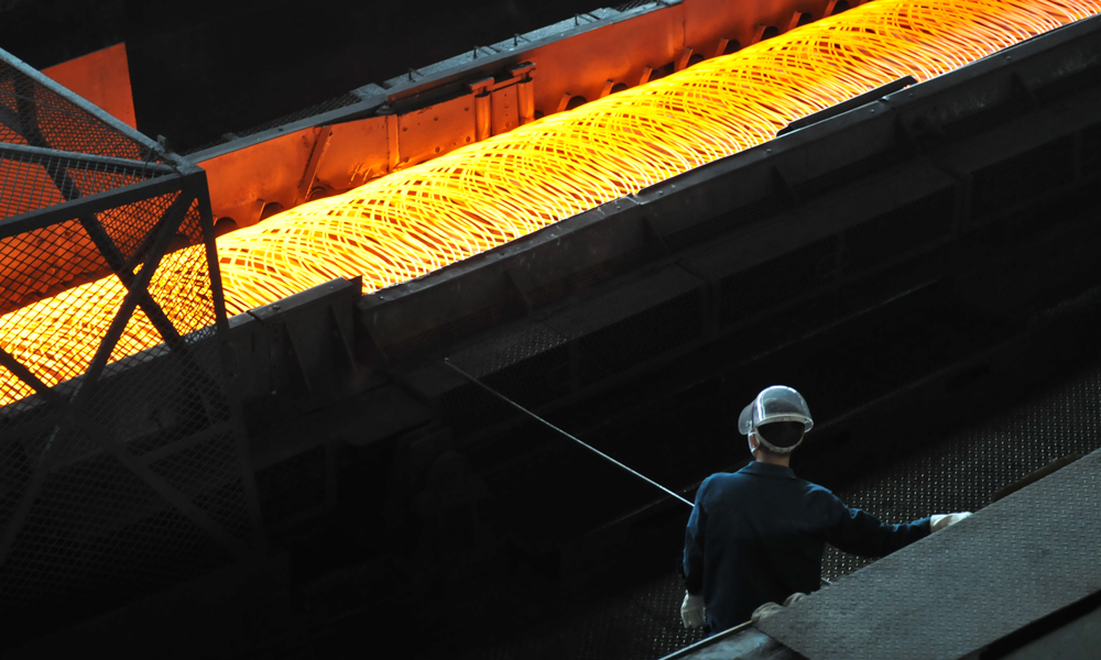 高速線材吐絲機冷床，青工專注的監守著設備。（作者：韓先明）