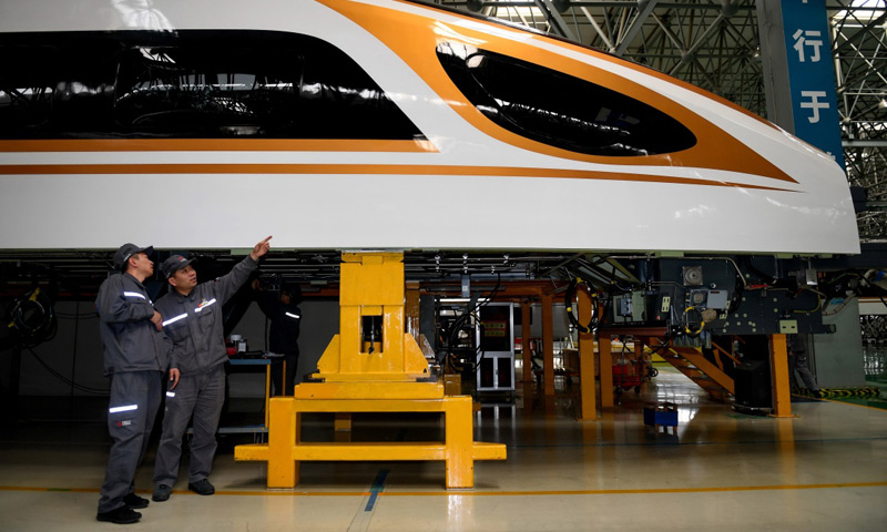 在自身成材的同時，周晶輝不忘對年輕工人的培養。中車長客高速動車組制造中心鋁車體二車間的年輕焊工臧鐵軍是周晶輝的徒弟，他說：“周師傅是車間公認的‘大拿’，休息時我們都會擠在他的工作室向他求教，有時他提點一句話就能讓我們少做幾小時的無用功。”圖為4月27日，周晶輝（右）與徒弟臧鐵軍研究高鐵車體改進工藝。（新華社記者 張楠 攝）