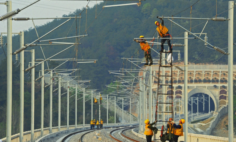 杭黃高鐵浙江段自2016年10月全面啟動電氣化施工以來，中鐵電氣化局集團公司針對該路段隧道和橋梁眾多、沿線交叉作業干擾頻繁等情況，嚴謹編制安全施工方案，精心組織施工人員施工，努力確保該段高鐵在2018年6月底完成電氣化主體工程。圖為3月30日，中鐵電氣化局集團公司施工人員在杭黃高鐵浙江桐廬段調整接觸網導線。（新華社記者 譚進 攝）