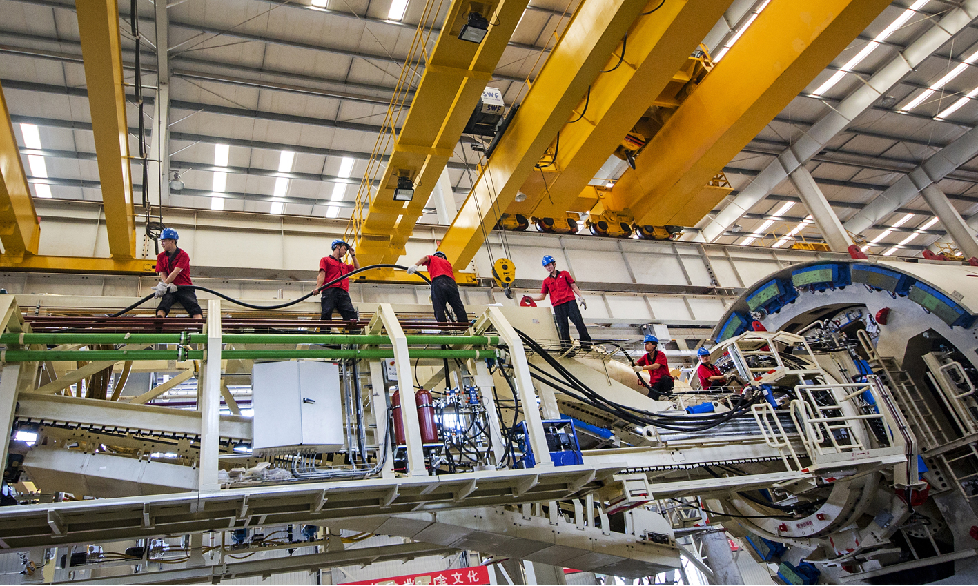 盾構機/TBM是一種集開挖、出渣及支護等功能于一體的大型隧道施工裝備，與傳統的隧道施工工法相比，盾構工法具有掘進速度快、隧道質量優、勞動強度低、地面擾動小等顯著優勢，已成為我國所有地下工程開挖及建設的首選工法。圖為中國鐵建重工集團員工一字排開，將電纜往目標位置輸送。