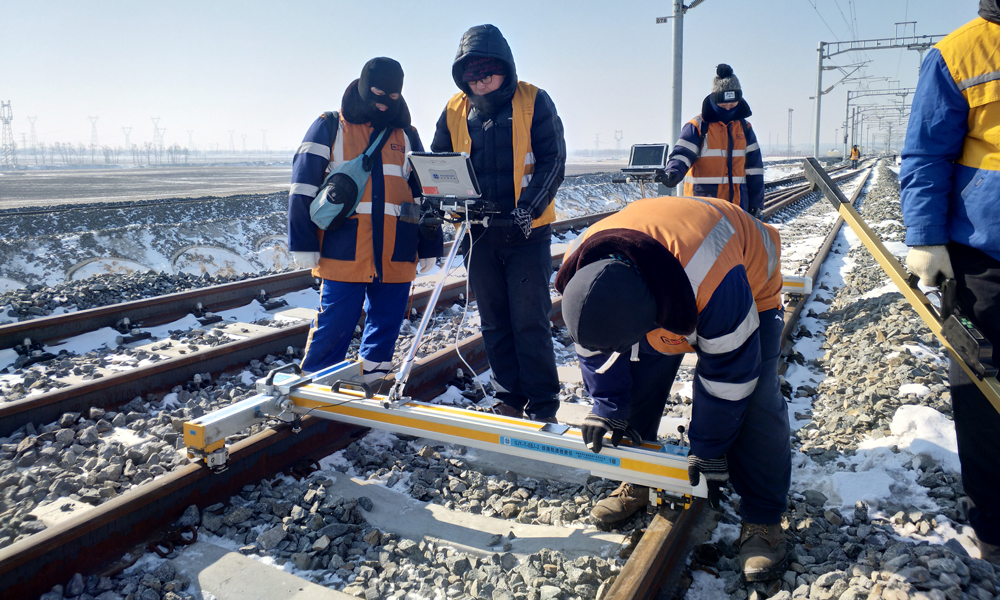 春寒料峭，乍暖還寒，3月的哈爾濱地區還是白茫茫一片。新建哈佳鐵路8標段，中國鐵建所屬二十三局二公司哈佳鐵路項目施工人員正用道尺逐點測量軌距，按照設計要求線路軌距調整至±1毫米以內，在現場作業時，技術人員高標準、嚴要求，將軌距允許誤差控制在±0.5毫米以內，對測量中有偏差的位置進行標記。