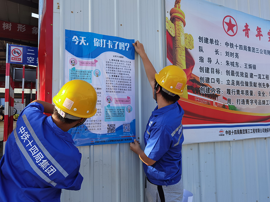 所屬項目每月定期在農民工維權公示欄張貼當月考勤表，農民工對考勤有異議的，可向管理人員申訴。他們還在集中居住處設立監督電話、發放監督卡、設置舉報信箱，充分賦予農民工監督權。圖為張貼實名制打卡宣傳海報。（周慧 攝）