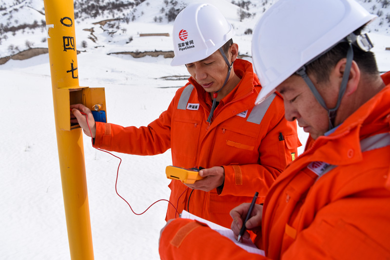 圖為2月4日，在西氣東輸二線果子溝段，管道巡護人員在測試陰極保護電位電壓。（新華社記者 丁磊 攝）