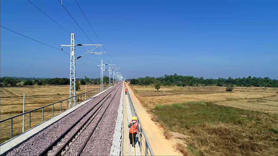 中老鐵路通信、信號工程由中國鐵建電氣化局承擔施工，全線敷設通信干線光纜1362.6公里，由萬象向磨丁方向敷設。其中萬象至萬榮區段通信干線光纜敷設共計391.1條公里，占總量的28%，萬榮至磨丁區段的通信干線光纜施工正在穩步有序推進。圖為人工敷設干線光纜航拍圖。