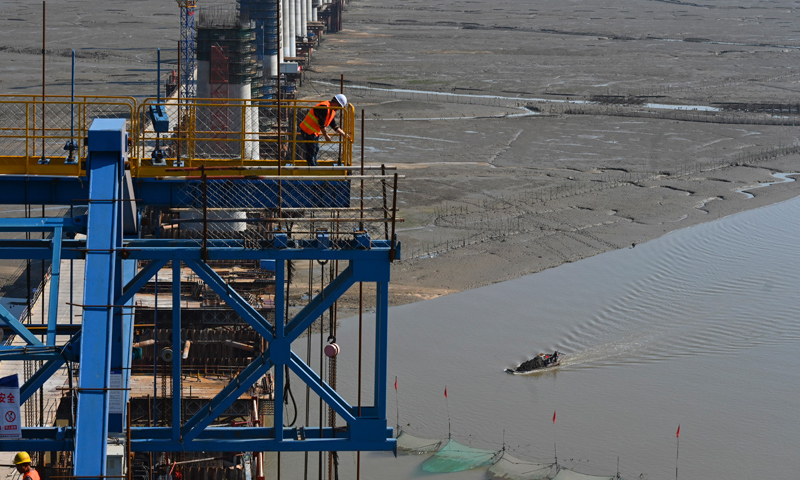 圖為2月15日，在新建福廈鐵路湄洲灣跨海大橋斜拉橋施工現場，一艘漁船從橋下經過。（新華社記者 宋為偉 攝）