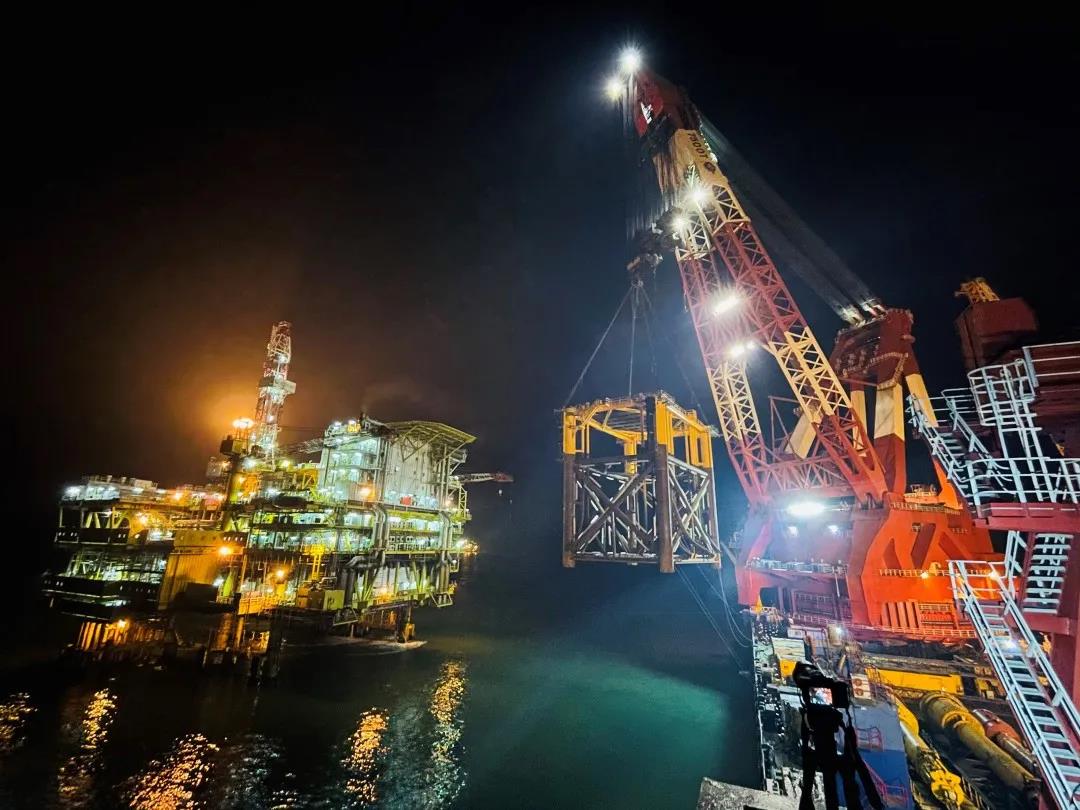 圖為2月19日19時，在距離秦皇島市30海里的海域，渤海油田岸電項目一期施工現場，“藍鯨號”正在積極籌備吊裝作業。緊鄰“藍鯨號”停靠的“德渤2號”駁船上，秦皇島32-6EPP和秦皇島32-6CEPL導管架正穩穩傲立于船上，等待“下水”。