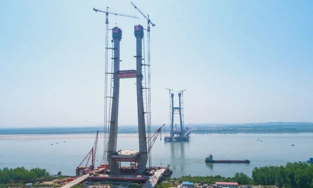 大橋主塔采用“H”形設計，北主塔高217.33米，南主塔高223米。建設者創新設計方式，攻克了大體積承臺混凝土澆注、超高主塔混凝土一次性垂直傳輸、大跨徑720米鋼混組合梁索力和成橋線型控制等多項世界難題。圖為大橋主塔封頂。
