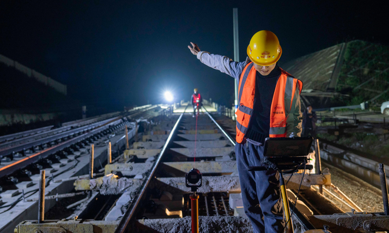 圖為4月12日晚，在湖北省南漳縣境內的鄭萬高鐵南漳站，中鐵十一局技術人員對無砟軌道進行精調。（新華社記者 杜華舉 攝）