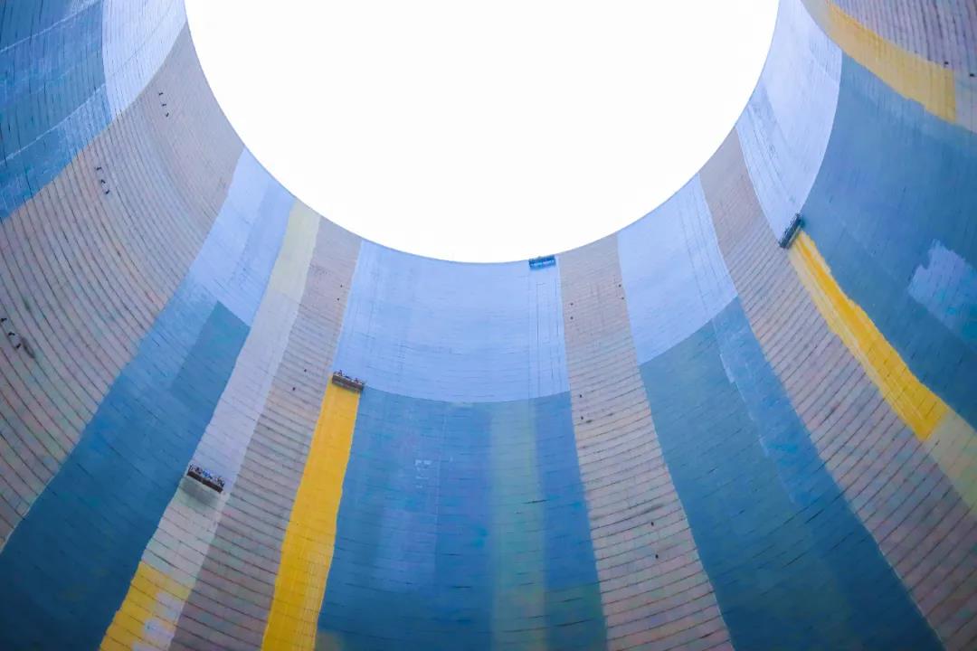 圖為近日，安徽電建二公司承建的湖南永州電廠一期百萬千瓦機組工程2號排煙冷卻塔內，施工人員正在進行外墻防腐作業。