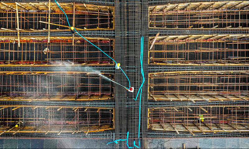 圖為5月1日，工人在珠海鶴港高速公路二期工程高欄港樞紐立交橋建設現場沖洗箱梁底板。（新華社記者 劉大偉 攝）