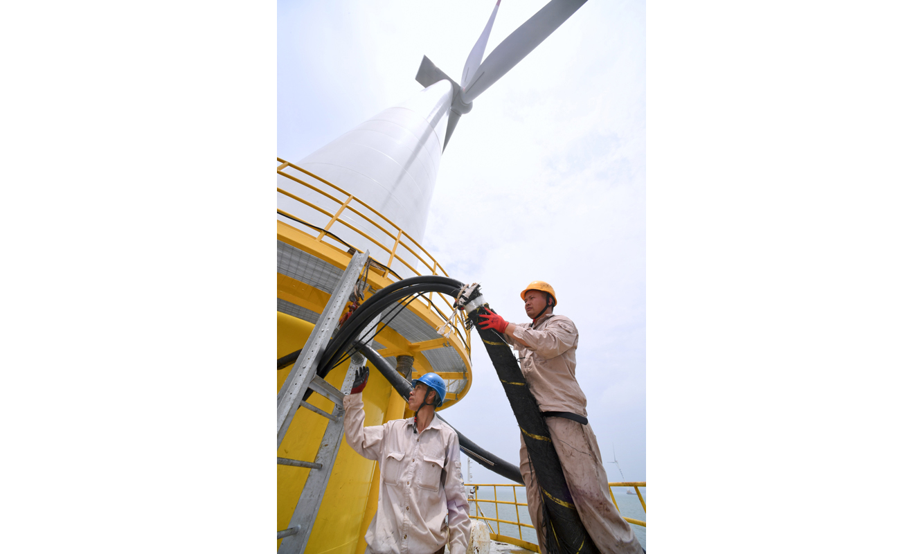 此次投運的海上風電主控系統以國產CPU處理器和自主研發的編程軟件為基礎，掌握了海上風電機組主控系統的自主設計、仿真測試、工程應用等全過程關鍵技術。圖為5月28日，在華電福清海壇海峽海上風電項目現場，工作人員在海上風電主控系統國產化機組上進行電路施工。（新華社記者 姜克紅 攝）