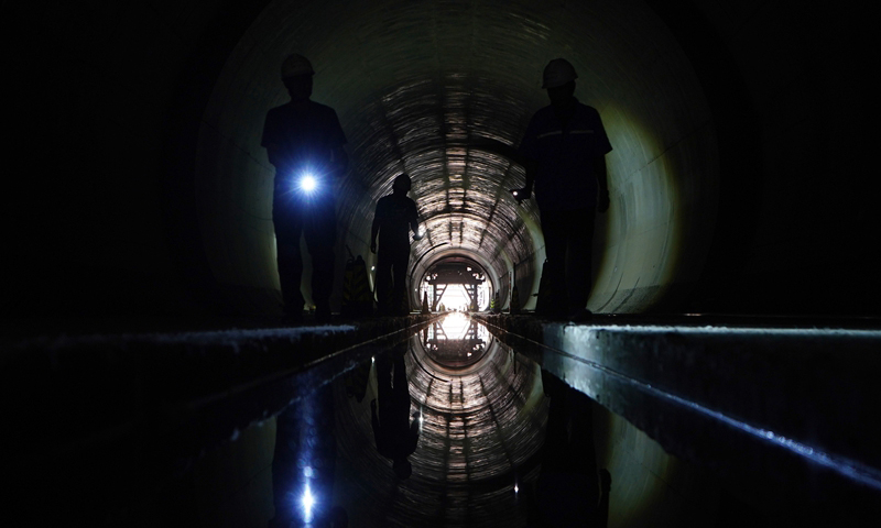 7月2日，北京新建城際鐵路聯絡線榆安二號隧道貫通，項目建設取得重要進展。新建城際鐵路聯絡線一期工程全長39.3公里，連接北京新機場和河北廊坊東站，設計時速200公里，預計2023年完工。圖為中鐵二十二局集團的工程師在北京新建城際鐵路聯絡線位于北京大興區的工地巡視。（新華社記者 邢廣利 攝）