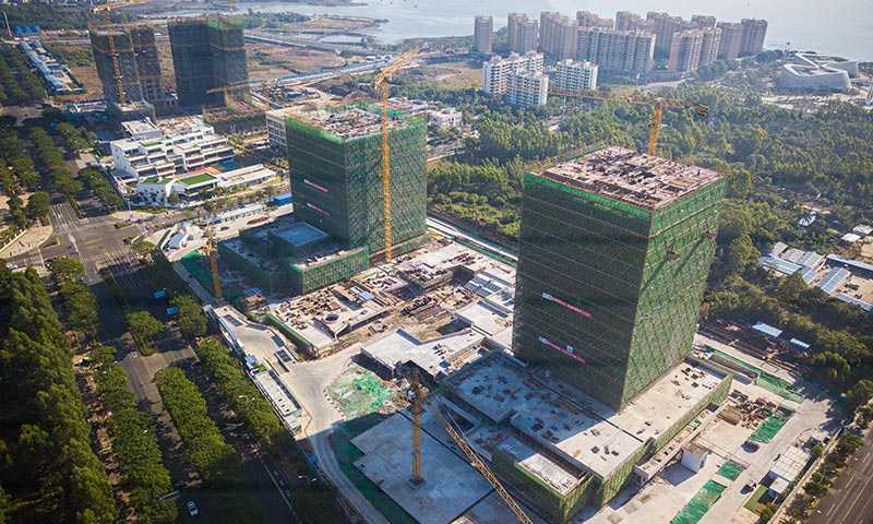 目前，在海南自貿港重點園區——洋浦經濟開發區，由中國能建葛洲壩二公司建設的洋浦國際航運大廈項目施工有序推進。圖為12月4日在海南洋浦經濟開發區拍攝的洋浦國際航運大廈項目（無人機照片）。（新華社記者 蒲曉旭 攝）