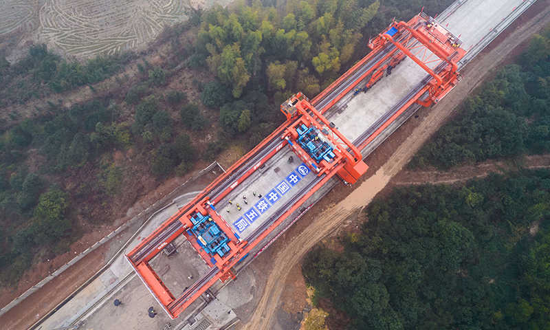 近日，常（德）益（陽）長（沙）鐵路全線箱梁架設完成，常益長鐵路建設取得階段性進展，為順利開通運營奠定了基礎。圖為中鐵五局工作人員在對常益長鐵路建設工地上最后一孔箱梁進行架設（無人機照片）。（新華社記者 陳思汗 攝）