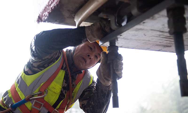 常益長鐵路線路全長約157公里，設計時速350公里，是國家“八縱八橫”高速鐵路網的重要組成部分。圖為在常益長鐵路建設工地，中鐵五局工作人員在為箱梁架設進行準備工作。（新華社記者 陳思汗 攝）