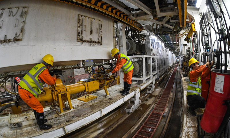 圖為施工人員在廣州地鐵10號線東湖站盾構井檢查調試盾構機設備管線。（新華社記者 劉大偉 攝）
