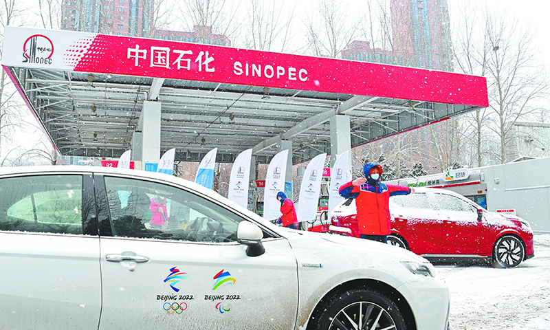 近日，北京冬奧會3個賽區迎來降雪。中國石化員工奮戰在一線，保障北京冬奧會期間油氣氫電平穩供應，成為漫漫大雪中的一道風景線。圖為北京石油冬奧會保供站——惠忠寺加油站員工引導冬奧會車輛加油。（胡慶明 攝 高君 文)  