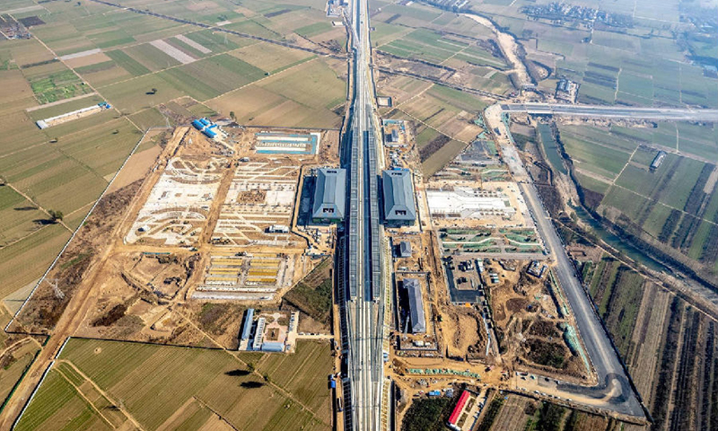 近日，濟鄭高鐵（濮陽至鄭州段）進入聯調聯試階段，由中國鐵建承建的濟鄭高鐵滑浚站全面亮相,該站房地處河南省安陽市滑縣與鶴壁市浚縣交界處，其南北站房分別位于滑縣、浚縣境內，是全國少有的“一站兩房”式高鐵站房。滑浚站投入運營后將正式結束兩縣不通高鐵的歷史。圖為濟鄭高鐵滑浚站航拍實景。