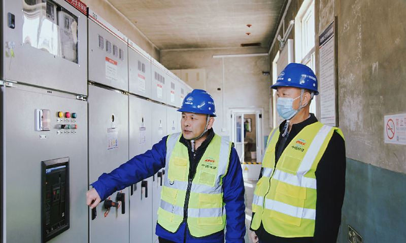 該項目可自動采集數據資料遠程監控，建成后運營期為25年，可持續提供清潔能源，對改善大氣環境，實現“碳達峰、碳中和”有積極作用。圖為技術人員在檢查光伏并網柜。