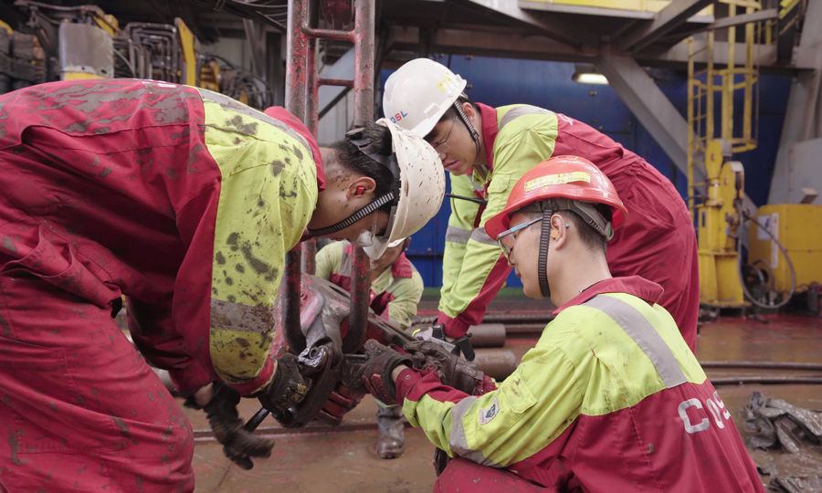 鉆臺工作人員更換吊卡。