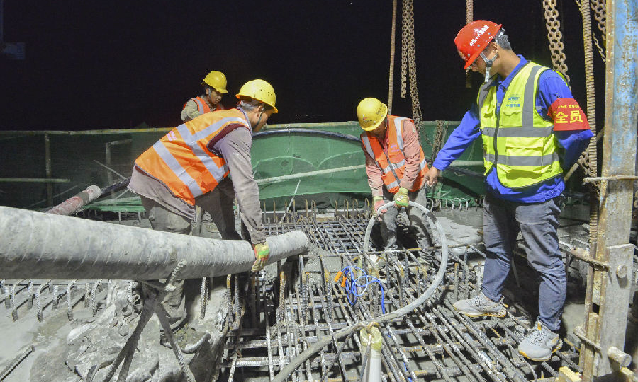六屋郁江特大橋全長1352米，跨越郁江的主橋跨度為238米，主墩高25米，墩跨比接近1∶10的設計極限，屬于典型的矮墩大跨剛構橋。大直徑樁基的施工、橋梁的線形和腹板質量是大橋施工的重中之重。圖為工人正在進行合龍段的混凝土澆筑施工。