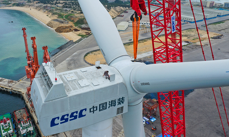 5月27日，工程人員登上完成總裝的國內首臺深遠海浮式風電裝備“扶搖號”發電機組頂部，準備進行解除吊纜作業。新華社記者 劉大偉 攝