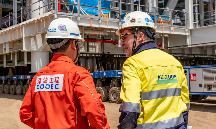 海油工程承攬了項目一期35個模塊建造工作，包括全部19個核心工藝模塊，總重約17.9萬噸。通過反復核算，海油工程將項目拆解為333個甲板片，經車間預制后，借助信息化技術，全力推進搭載工作，按計劃實現全部模塊的結構封頂作業。圖為制管裝船作業部技術員與場地管理（業主）溝通。侯憲鵬 攝