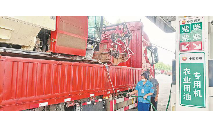  近期，安徽省4200多萬畝小麥豐收在望。中國石油安徽銷售公司及時調整汽柴油運力分配，精準保供。圖為工作人員在用油專用綠色通道為農機手進行加油服務。 