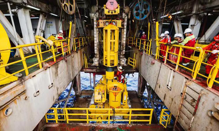 水下采油樹是海洋油氣水下生產系統的核心組成部分，也是構建水下油氣井生產管柱的基礎，該裝備重量達到55噸，由超過2500個零部件組成，具備安全隔離儲油層、保證井下作業安全等功能，可有效降低項目成本。圖為今年5月份，國產深水水下采油樹在月池就位，中國海油工程師正在安裝采油樹保護框架導向樁。