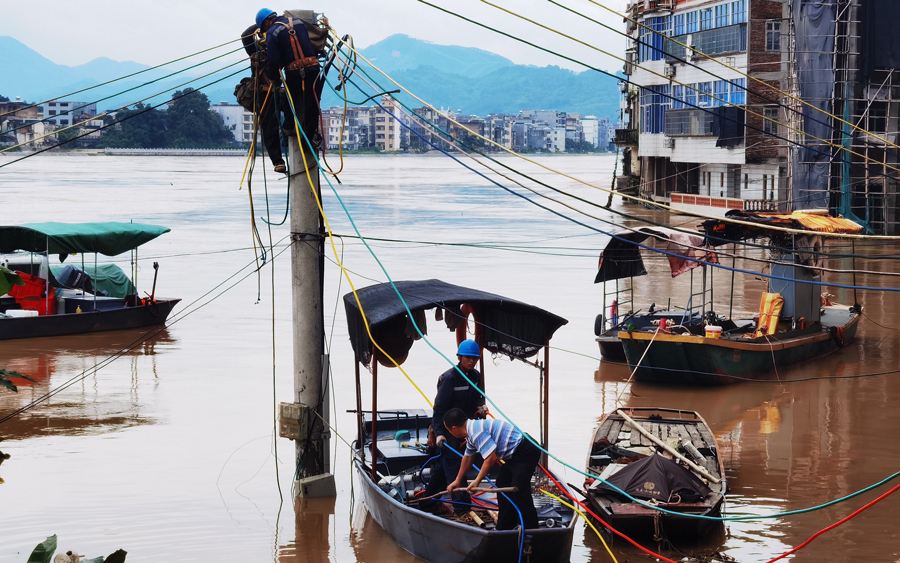 6月17日凌晨，廣東梅州豐順縣留隍站點水位最高23.64米，超警戒線1.64米，轄區內部分供電設施被洪水淹沒導致停電。梅州豐順供電局留隍供電所工作人緊急開展搶修，熱心群眾主動提出用自家小艇載工作人員到水中央開展工作。劉少華 攝