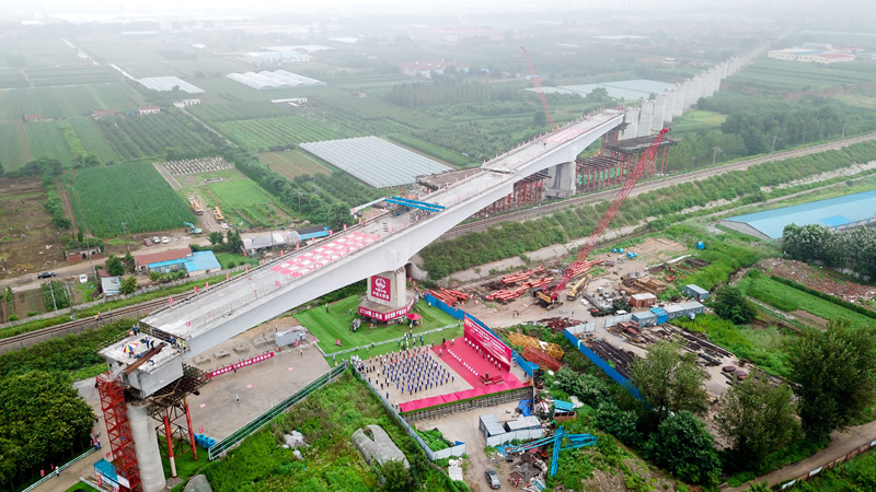 7月13日，在山東省龍口市，中鐵大橋局的工作人員在對濰煙高鐵跨龍煙鐵路126米連續梁雙“T”構進行同時轉體作業（無人機照片）。新華社記者 郭緒雷 攝