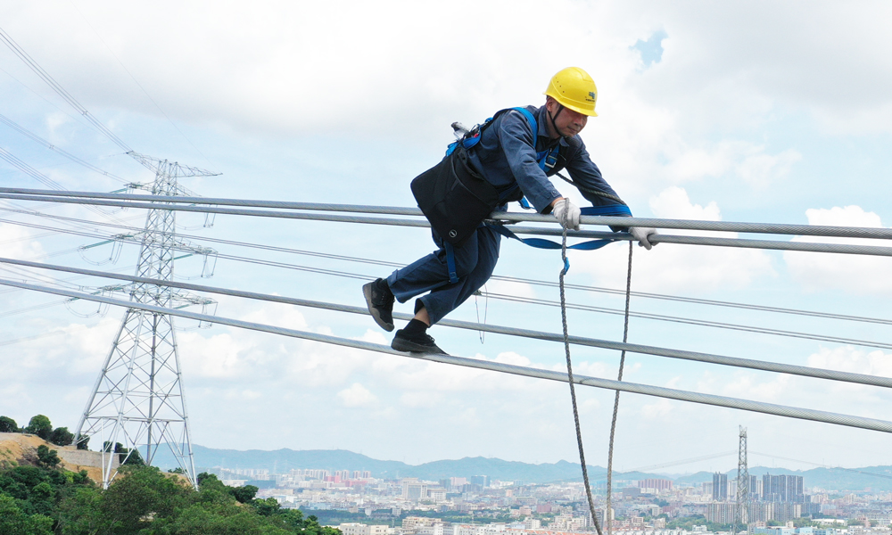 近日，為確保新建線路按期投產運行，南方電網廣東東莞供電局輸電管理所的工作人員頭頂陽光，在百米高空“踏空”而行，細致地檢查每一寸導線可能存在的缺陷及隱患，確保驗收工作高質量完成。嚴小龍 宋睿 攝