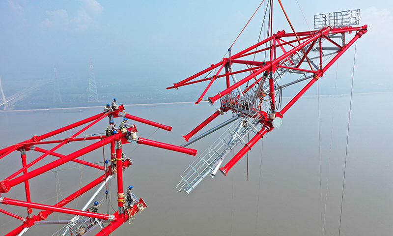 白浙線是我國實施“西電東送”戰略的重點工程，送端連接目前世界在建最大水電站白鶴灘水電站，受端位于杭州臨平區浙北換流站，線路全長2140.2公里。圖為8月1日，安徽送變電工程有限公司施工人員在池州長江大跨越南岸跨越塔封頂施工現場作業（無人機照片）。趙獻富 攝