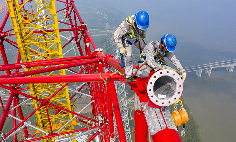 8月1日，安徽送變電工程有限公司施工人員在池州長江大跨越南岸跨越塔封頂施工現場作業（無人機照片）。鄭賢列 攝