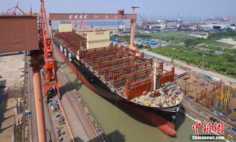 該船由滬東中華自主設計，擁有完全自主知識產權，入DNV船級社。該船總長399.99米，比目前世界最大航母還要長60多米；型寬61.5米，甲板面積相當于近4個標準足球場；型深33.2米，最大堆箱層數可達25層，相當于22層樓的高度，可承載24萬多噸貨物，一次可裝載創紀錄的24116只標準集裝箱，是目前全球裝箱量最大的集裝箱船，是名副其實的海上“巨無霸”和“帶貨王”。圖為24116TEU超大型集裝箱船在長興造船基地順利出塢。 張黎 攝