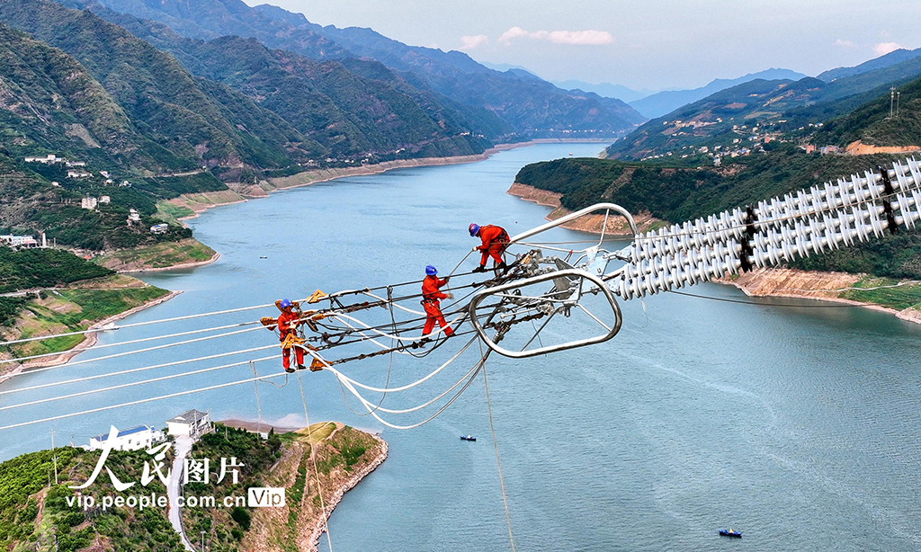 近段時間，湖北恩施地區持續高溫天氣，為保證國家重點工程白鶴灘——浙江±800千伏特高壓直流輸電工程施工進度，電力工人冒著高溫酷暑，奮戰在施工現場。圖為2022年8月20日，湖北省恩施土家族苗族自治州巴東縣東瀼口鎮綠竹筏村，電力工人冒著40℃以上的高溫跨越長江施工作業。張遠明 攝