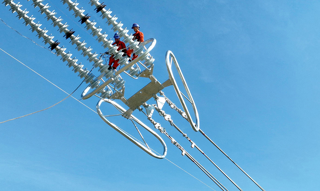 2022年8月20日，湖北省恩施土家族苗族自治州巴東縣東瀼口鎮綠竹筏村，電力工人冒著40℃以上的高溫跨越長江施工作業。張遠明 攝