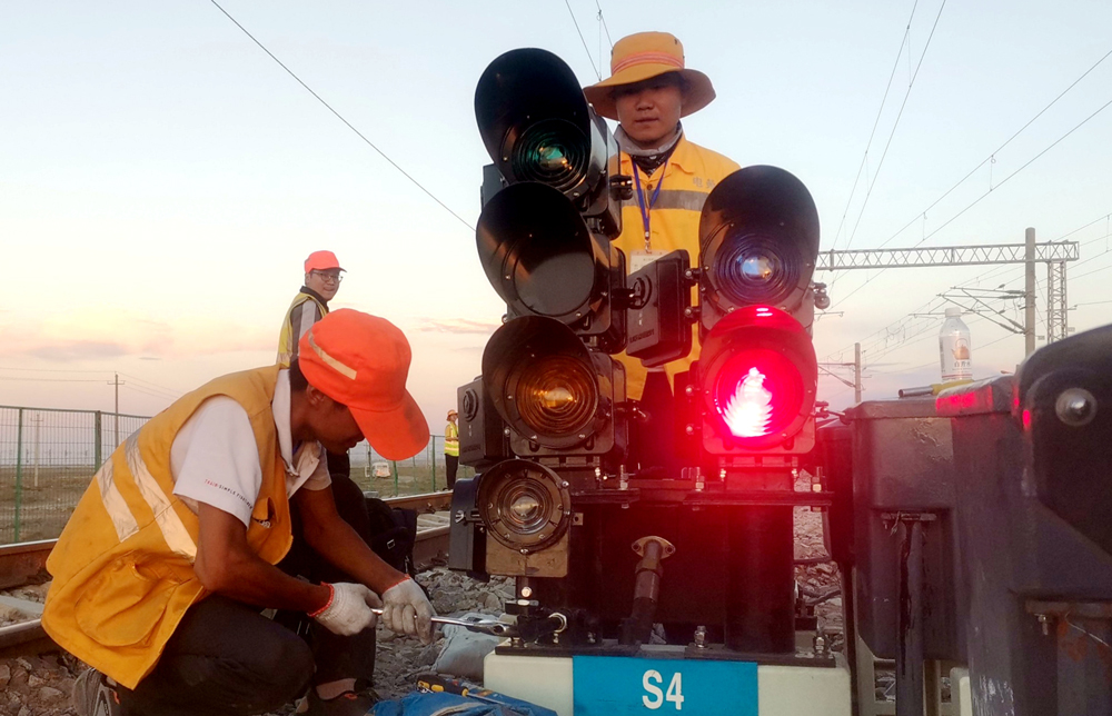 自2019年以來，中鐵電氣化局先后承擔了蘭新鐵路武威南駝峰場等12個站點計算機聯鎖室內外設備更新工程。項目員工克服高海拔、晝夜溫差大、接口配合要求高等困難，充分協調施工組織、人員物資，高效完成了改造任務。圖為安裝新信號機設備。