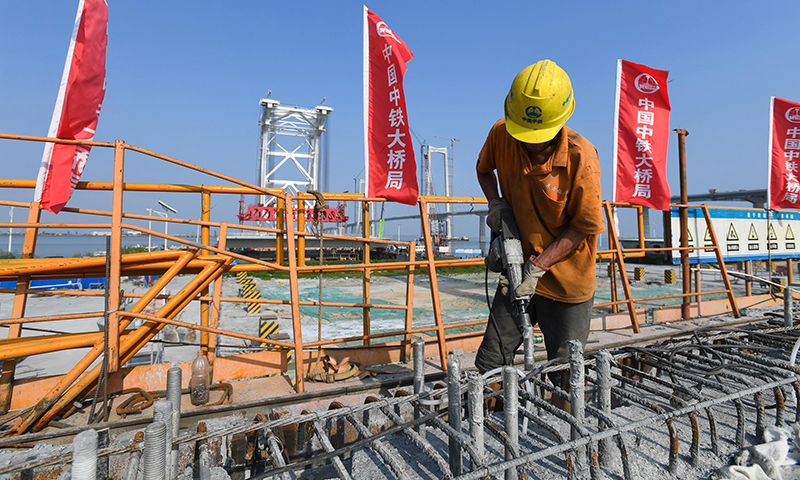 10月8日，施工人員在中山智慧梁場的第155片60米混凝土箱梁上進行鑿毛作業。新華社記者 劉大偉 攝