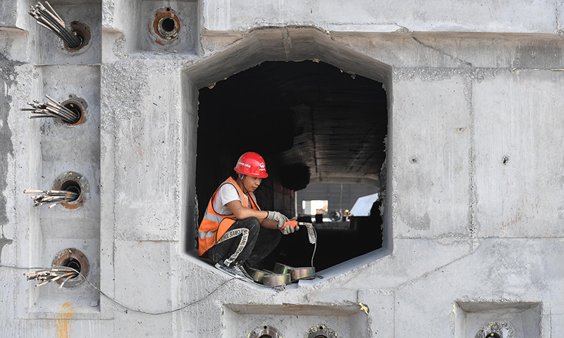 10月8日，施工人員在中山智慧梁場的第155片60米混凝土箱梁上進行隔墻作業。新華社記者 劉大偉 攝