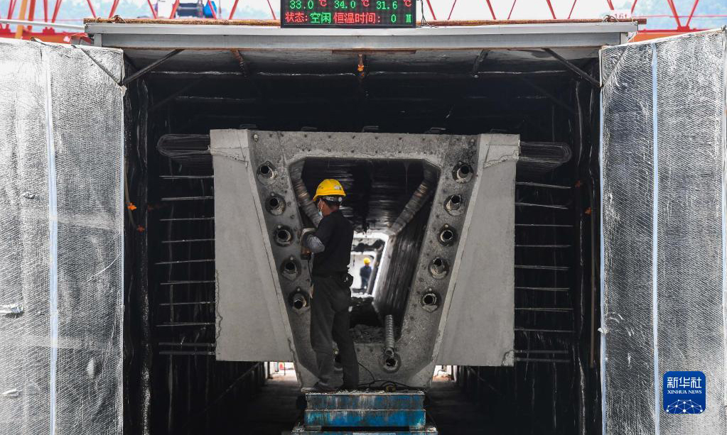 黃茅海跨海通道橫跨珠江口崖門入海口黃茅海水域，連接珠海高欄和江門臺山，線路全長約31公里，預計2024年建成通車。圖為10月18日，工人對一片剛完成智能蒸養的預制箱梁進行銜接面打毛。完成混凝土澆筑的預制箱梁需要進行蒸養作業，以增加結構強度。新華社記者 劉大偉 攝