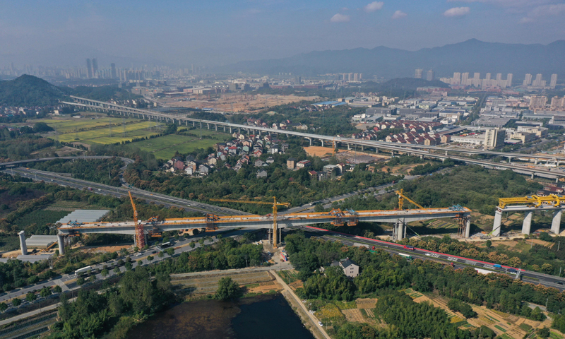 10月20日拍攝的杭溫鐵路二期工程跨杭黃鐵路特大橋完成合龍的最大跨度連續梁（無人機照片），該連續梁同時上跨杭新景高速公路和桐廬縣鳳川大道。新華社記者 黃宗治 攝